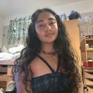 Selfie of Rishita in her room. She has long wavy hair and is wearing a black tank top.